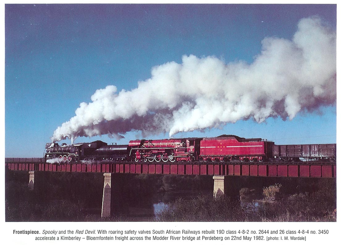 Frontpiece - 'Spooky' and 'The Red Devil' - With roaring safety valves, SAR rebuilt 19D class 4-8-2 No 2644 and 26 class 4-8-4 No 3450 accelerate a Kimberley-Bloemfontein freight across the Modder River on 22 May 1982.